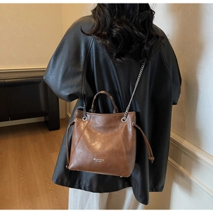 Vista posteriore di una modella che indossa la borsa tote vintage marrone con catena