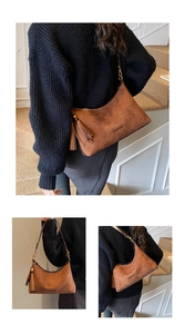 Detail of vintage brown suede dumpling bag with tassel charm and gold hardware
