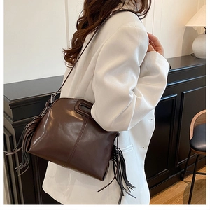 Vue détaillée du sac en cuir marron foncé avec de longues franges élégantes sur le côté
