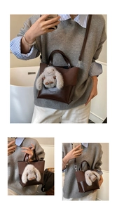 Detail view of dark brown leather bucket bag with cute plush rabbit pendant accessory