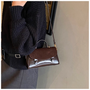 Dettaglio borsa a spalla vintage marrone caffè con texture miste e fibbie in oro