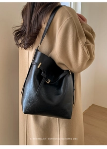 Détail de la texture cuir noir et boucle en métal sur un cabas rétro chic