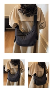 Detail view of the large capacity black nylon crossbody bag styled with a trench coat