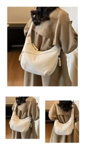 Detail view of large white canvas crescent bag with thick woven rope zipper puller