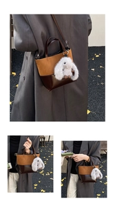 Detail view of caramel brown leather bucket bag with cute white plush rabbit charm