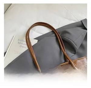 Détail du sac cabas en cuir ciré marron vintage avec pompon et perles en bois décoratifs