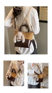 Detail view of retro bucket bag with color-block leather and plush rabbit pendant charm