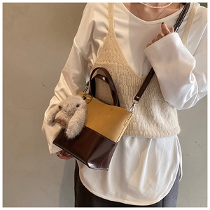 Detail of vintage bucket bag with yellow suede and brown faux leather patchwork