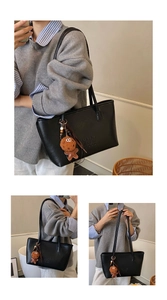 Détail du sac cabas noir avec lettrage embossé et breloque bonhomme de pain d'épices