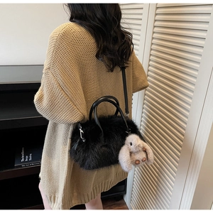 Détail du sac cabas en peluche noire avec breloque lapin blanc et anses en cuir