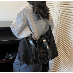 Grand sac cabas noir avec coutures contrastées blanches et bandoulière réglable sur modèle