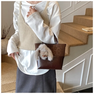 Detailed view of vintage leopard print bucket bag with cute plush rabbit charm