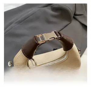 Detailed view of the woven canvas bucket bag featuring a golden clasp and leather handle