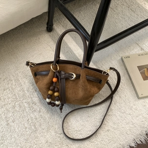 Détail du sac en daim marron foncé avec perles en bois colorées et boucle en cuir élégante