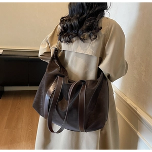 Détail d'un sac cabas vintage avec coutures contrastées et bandoulières variées