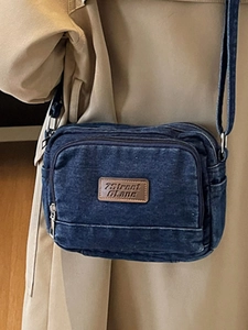 Sac bandoulière tendance en denim bleu foncé avec écusson en cuir et doubles compartiments