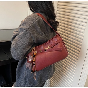 Détail du sac à bandoulière rouge vintage avec texture mate et charmant ours