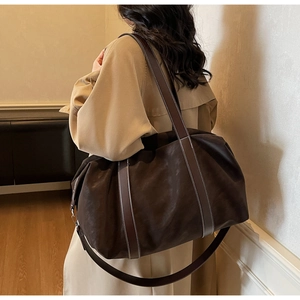 Vue détaillée du sac cabas en daim marron avec surpiqûres contrastées sur les anses