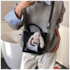 Detail of black patchwork crossbody bucket bag with leopard print trim and plush bunny charm