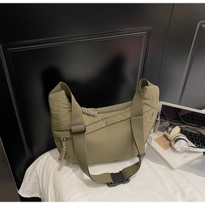Detail of olive green crescent crossbody bag with wide shoulder strap and plastic buckle