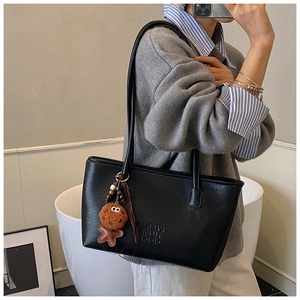 Détail du sac cabas noir texturé avec gaufrage MALIVI et charm en forme de biscuit