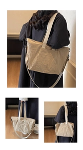 Detail of beige tote bag with crinkled texture, wide handle, and adjustable shoulder strap
