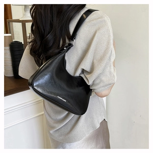 Close-up of a black leather crescent hobo bag featuring silver Fashion & Bags text detail
