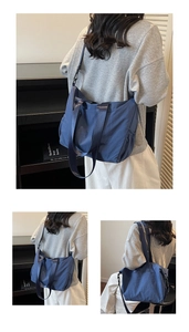 Detail view of large dark blue nylon tote bag showing durable straps and soft pleated texture