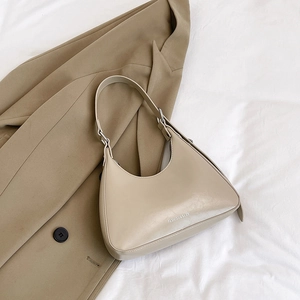 Detail of light beige hobo underarm bag with Fashion & Bags print on soft textured leather