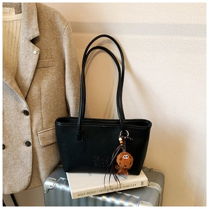 Détails du sac cabas vintage en cuir noir avec gaufrage et breloque en peluche douce