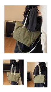 Detail of olive green nylon tote bag showing wrinkled texture and wide carrying straps