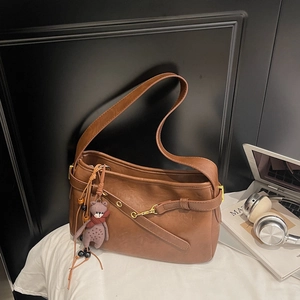 Détails du sac à bandoulière en cuir marron avec anneau doré et breloque ours