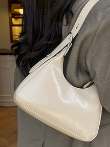 Minimalist cream crescent underarm bag in glossy finish with adjustable strap for women
