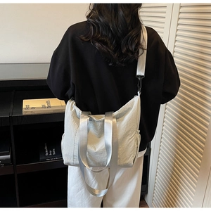 Detail of grey large capacity tote bag featuring wide strap and textured fabric