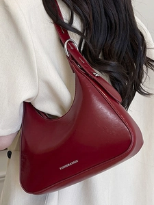 Fashionable burgundy crescent underarm bag in glossy leather with white logo print
