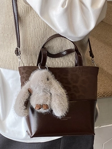 Retro brown bucket bag with leopard print paneling and a cute plush rabbit charm