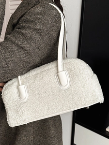 Sac à épaule en peluche blanche avec poignées en cuir porté par un mannequin en manteau