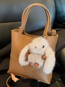 Brown litchi grain bucket bag with cute plush rabbit charm and top handle