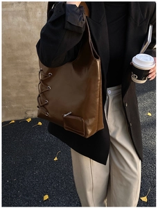 Detail of dark brown hobo bag with lace-up side design and matching mini coin purse