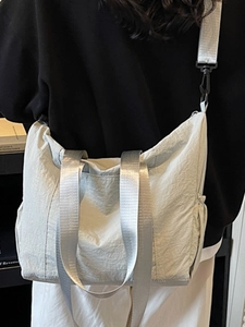 Light grey nylon tote bag with wide straps and side pockets for casual daily commute