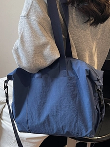 Large navy blue nylon tote bag for commuting, worn by model for size visualization