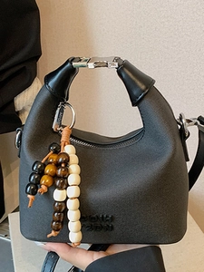 Elegant black textured handbag with unique metal buckle and colorful wooden bead charm