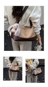 Detailed view of the pleated beige and dark brown shoulder bag with a plush bunny charm