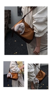 Detail of a large crossbody bag in ginger with brown leather strap and a plush rabbit charm