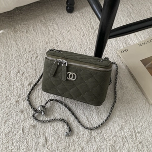 Detail of green quilted suede vanity box bag with silver interlocking logo and chain strap