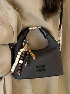 Minimalist black handbag with unique beaded charms and COIH 2DN embossed design