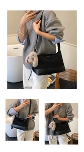 Detail of black crossbody bag with nylon texture and a cute brown bunny plush charm