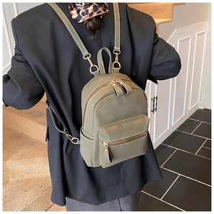 Detail view of olive green backpack featuring matte texture and premium gold zippers