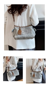 Vue détaillée d'un sac hobo en toile grise vieillie avec garniture marron et bandoulière