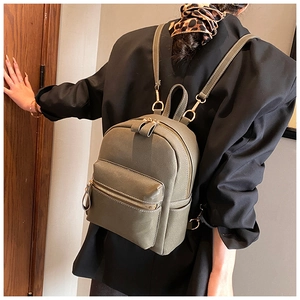 Detail view of olive green mini backpack featuring lychee texture and golden hardware